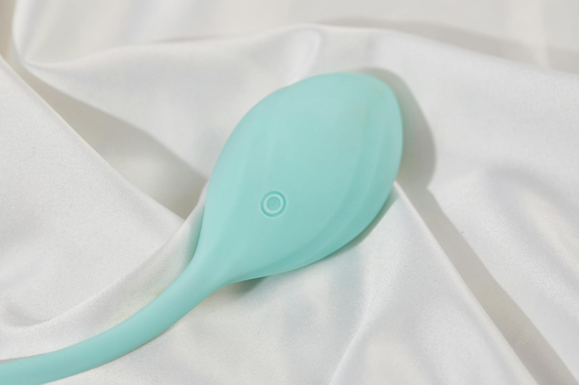 Woman holding blue and pink silicone vibrators in a thoughtful moment
