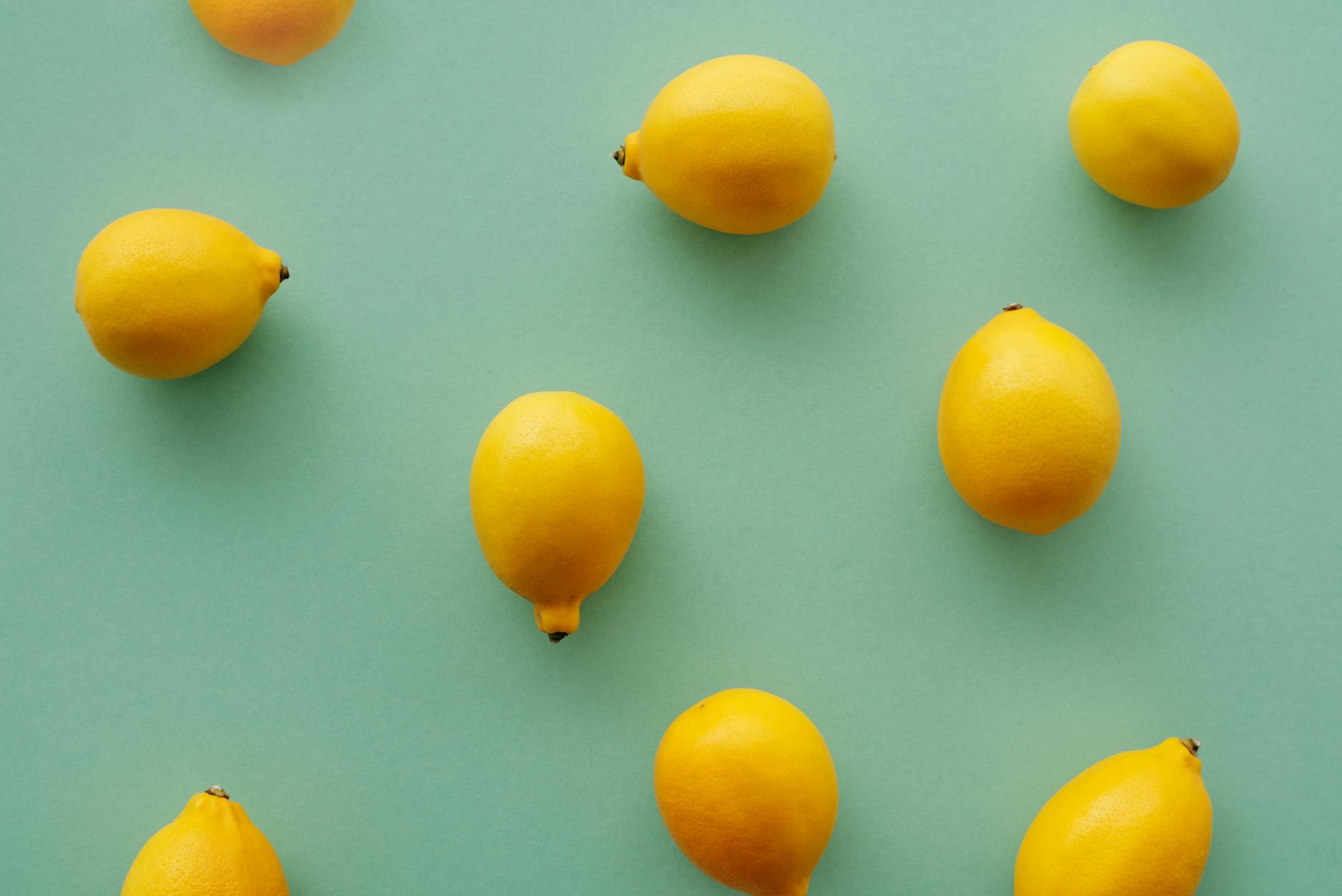 Bright yellow lemons arranged on a pastel background symbolizing renewal and fresh sensation