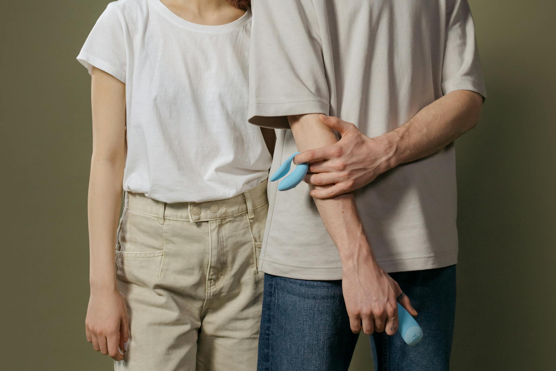Hand holding an orange vibrator against a minimalistic purple backdrop, symbolizing modern solo exploration.