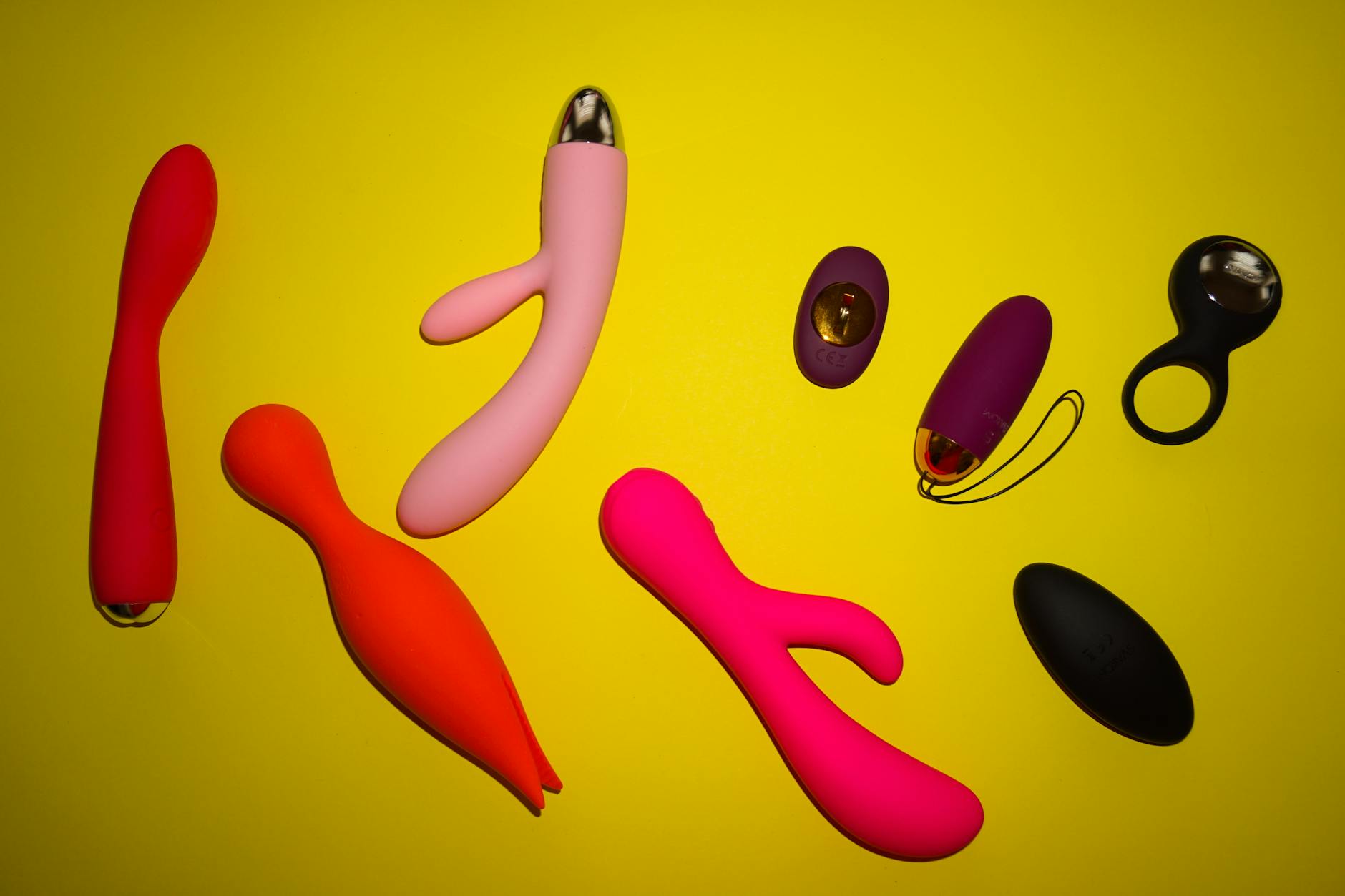 Colorful vibrators arranged on yellow background showing diverse design options